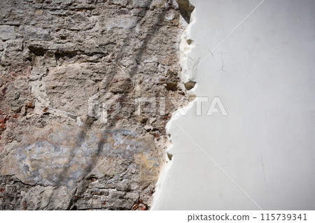 The brick wall is visible from under the white plaster. 115739341