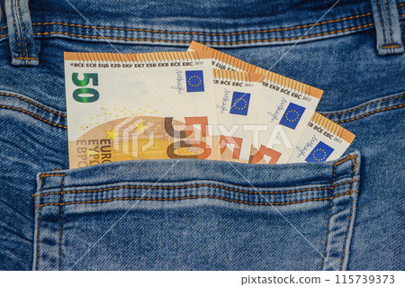 Stack of denim jeans with euro notes in pocket Stack of denim jeans with euro notes in pocket 115739373