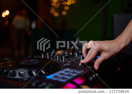 control DJ for mixing music with blurred people dancing at party in nightclub. control DJ for mixing music with blurred people dancing at party in nightclub. 115739634