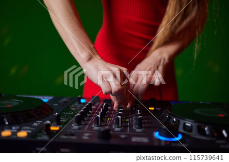 control DJ for mixing music with blurred people dancing at party in nightclub. 115739641