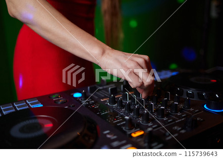 control DJ for mixing music with blurred people dancing at party in nightclub. control DJ for mixing music with blurred people dancing at party in nightclub. 115739643