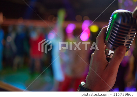 Music artist with body jewelry sings into microphone at concert 115739663