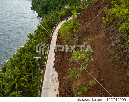 Flying over the road with rockfalls and mudslidesl from mountain cliff. Philippines. Flying over the road with rockfalls and mudslidesl from mountain cliff. Philippines. 115740009