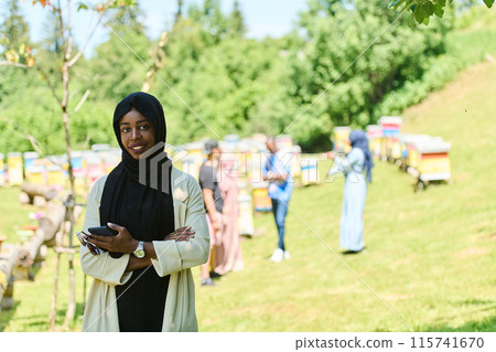 Empowered Middle Eastern Muslim Woman in Hijab Balances Modern Technology and Traditional Beekeeping Business 115741670