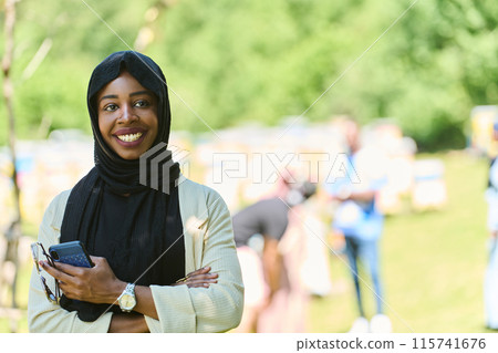Empowered Middle Eastern Muslim Woman in Hijab Balances Modern Technology and Traditional Beekeeping Business Empowered Middle Eastern Muslim Woman in Hijab Balances Modern Technology and Traditional Beekeeping Business 115741676