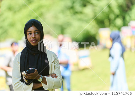 Empowered Middle Eastern Muslim Woman in Hijab Balances Modern Technology and Traditional Beekeeping Business 115741766