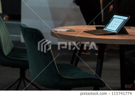 digital tablet computer placed on a wooden table in a modern office 115741774