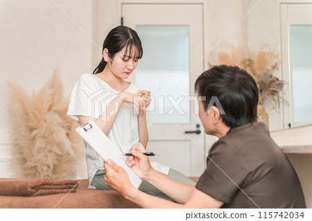 一名婦女和一名脊椎按摩師/治療師因手指受傷而前往脊椎按摩診所、整骨診所進行按摩。 一名婦女和一名脊椎按摩師/治療師因手指受傷而前往脊椎按摩診所、整骨診所進行按摩。 115742034
