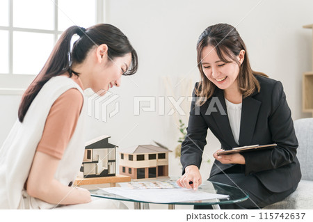 一位亞洲女性向一位女商人提供諮詢，女商人解釋並出售她的房屋、房地產、裝修和資產管理。 115742637