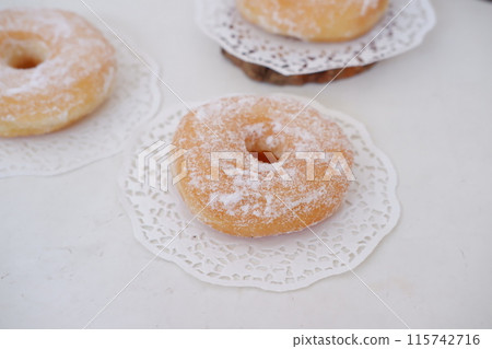 donuts with powdered sugar on top as a background donuts with powdered sugar on top as a background 115742716