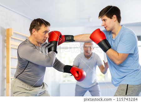 Portrait of active athletes competing in boxing gloves in boxing ring 115743284