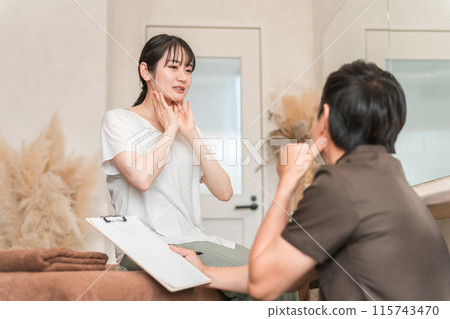 A woman receiving lymphatic massage and lymphatic massage counseling and a therapist 115743470