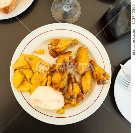 Tasty chicken wings with with gravy and potatoes Tasty chicken wings with with gravy and potatoes 115743596