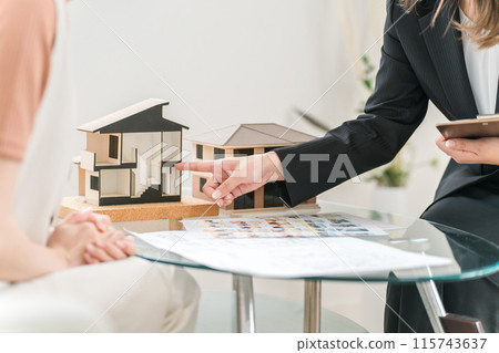 The hands of a house planner/house builder saleswoman explaining and planning the floor plan using a house model The hands of a house planner/house builder saleswoman explaining and planning the floor plan using a house model 115743637