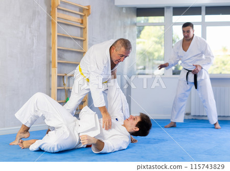 Young and elderly men training judo fight Young and elderly men training judo fight 115743829