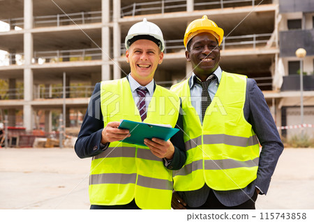 Portrait of two successful contented architects at construction site 115743858