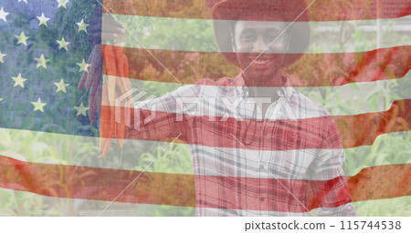 Image of flag of united states of america over happy african american farmer keeping carrots 115744538