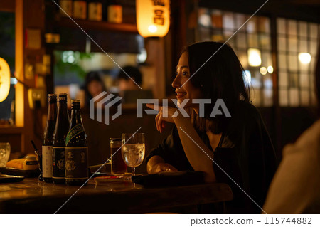 Woman drinking at a bar 115744882