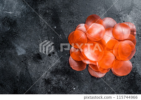 Raw kerupuk or prawn shrimp crackers, chips. Black background. Top view. Copy space Raw kerupuk or prawn shrimp crackers, chips. Black background. Top view. Copy space 115744966