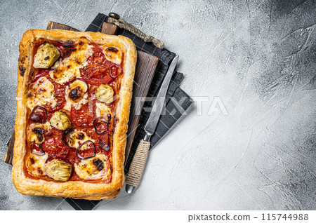 Vegetarian puff pastry pizza with artichoke, mozzarella, tomatoes and cheese. White background. Top view. Copy space Vegetarian puff pastry pizza with artichoke, mozzarella, tomatoes and cheese. White background. Top view. Copy space 115744988