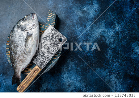 Sea bream or dorado fish on fish market cutting board. Blue background. Top view. Copy space 115745035