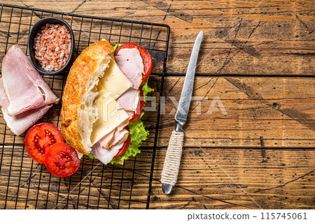 Sub sandwich with ham, cheese, tomato and Lettuce. Wooden background. Top view. Copy space Sub sandwich with ham, cheese, tomato and Lettuce. Wooden background. Top view. Copy space 115745061
