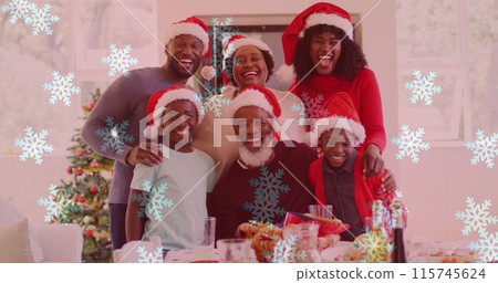 Image of snow falling over smiling family with santa hats embracing 115745624