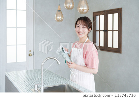 A woman wiping dishes in the kitchen (housework, housewife) A woman wiping dishes in the kitchen (housework, housewife) 115745736
