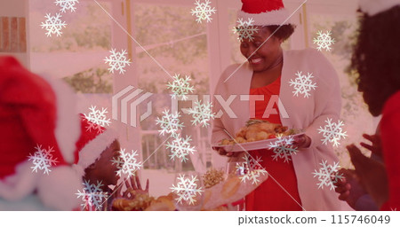 Image of snow falling over smiling family with santa hats having dinner Image of snow falling over smiling family with santa hats having dinner 115746049