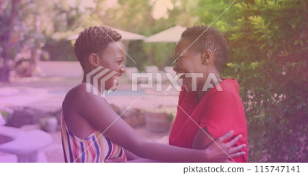 Two african american sisters hugging each other at a resort Two african american sisters hugging each other at a resort 115747141