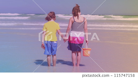 Rear view of caucasian brother and sister standing at the beach 115747158