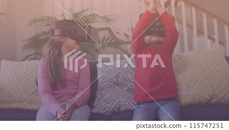 Spots of light against caucasian brother and sister wearing vr headset at home Spots of light against caucasian brother and sister wearing vr headset at home 115747251