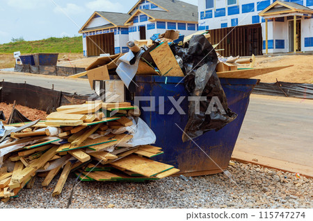 When house is being constructed, metal garbage container is used to dispose of construction waste When house is being constructed, metal garbage container is used to dispose of construction waste 115747274
