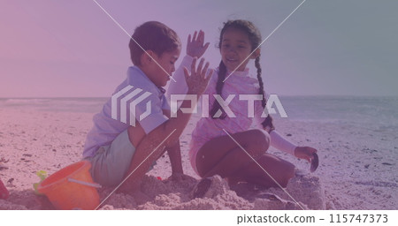 Spots of light against hispanic brother and sister high fiving each other at the beach 115747373