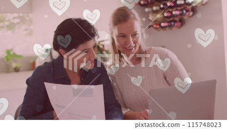 Image of hearts over caucasian female couple sitting at table and using laptop Image of hearts over caucasian female couple sitting at table and using laptop 115748023