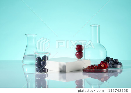 The promotional photo of blueberry and cherry theme, was shot from front over the blue texture. An empty podium in center, surrounded by several ripe cherry and blueberry contained in lab tools The promotional photo of blueberry and cherry theme, was shot from front over the blue texture. An empty podium in center, surrounded by several ripe cherry and blueberry contained in lab tools 115748368