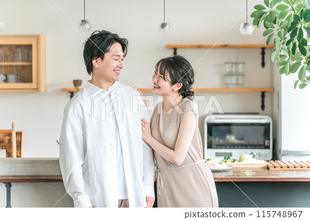 A married couple, lover, or partner laughing in the kitchen or dining room of their home A married couple, lover, or partner laughing in the kitchen or dining room of their home 115748967