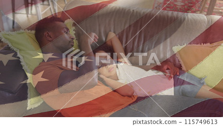 Image of flag of usa waving over african american father lying on sofa with sleeping daughter 115749613