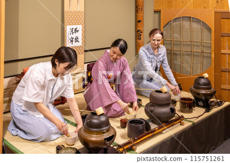 Foreign female tourists experiencing a tea ceremony and a Japanese female guide Foreign female tourists experiencing a tea ceremony and a Japanese female guide 115751261