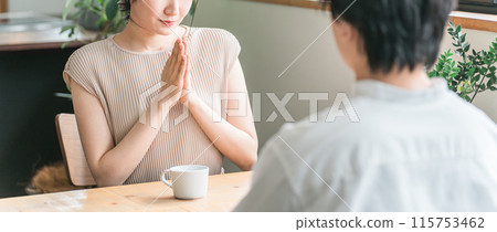 A woman apologizing to a man at a cafe, eatery, or restaurant on a date A woman apologizing to a man at a cafe, eatery, or restaurant on a date 115753462