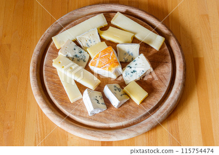 Cheese platter with different kinds of cheese on wooden table 115754474