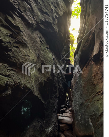 man tourist hiking by rocks on forest man tourist hiking by rocks on forest 115754741