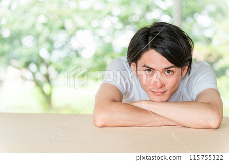 身穿鮮綠色背景白色 T 恤的亞洲年輕男子 身穿鮮綠色背景白色 T 恤的亞洲年輕男子 115755322