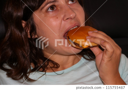 Caucasian woman eating tasty cheeseburger Caucasian woman eating tasty cheeseburger 115755487