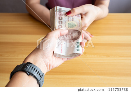 Cropped shot view of someone giving a pile of money (Thailand 1,000 Baht) to other person. Thai baht is the official currency of Thailand. Cropped shot view of someone giving a pile of money (Thailand 1,000 Baht) to other person. Thai baht is the official currency of Thailand. 115755788