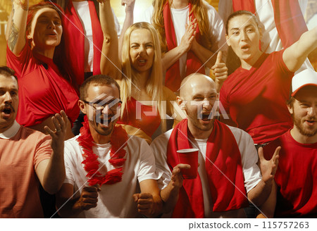 Group portrait of emotional people, fans standing on tribunes and loudly shouting to support their team. People in scarfs with drinks. Group portrait of emotional people, fans standing on tribunes and loudly shouting to support their team. People in scarfs with drinks. 115757263