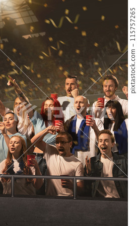 Overjoyed, excited people standing on arena, drinks beer while their favorite team scoring goal and festive confetti rains down on them Overjoyed, excited people standing on arena, drinks beer while their favorite team scoring goal and festive confetti rains down on them 115757265