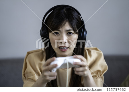 A middle-aged woman engrossed in a game A middle-aged woman engrossed in a game 115757662