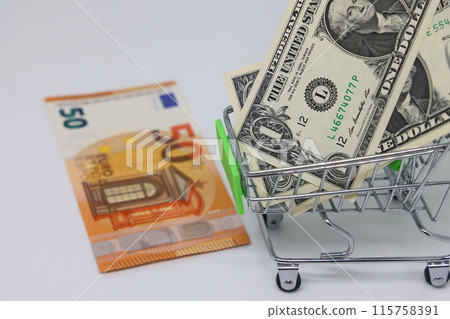 Toy grocery cart and banknotes, shopping for goods, exchange rate volatility. Toy grocery cart and banknotes, shopping for goods, exchange rate volatility. 115758391
