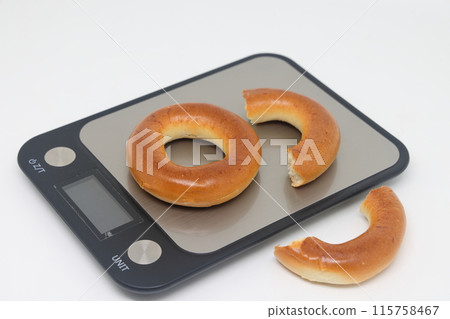 Bagels sit on an electronic kitchen scale, placed on the scales, proper nutrition, calorie counting. 115758467